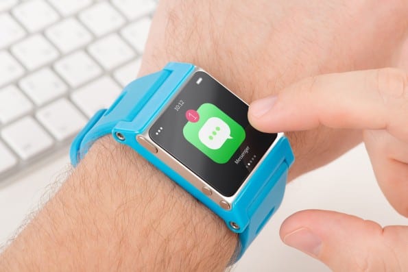 Finger taps messenger icon on blue smart watch