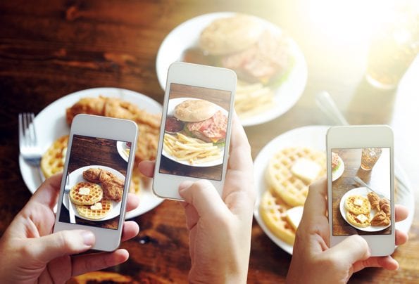 Fotolia_68636407_friends using smartphones to take photos of food © Joshua Resnick - Fotolia