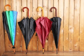 Bright umbrellas leaning against a wooden wall