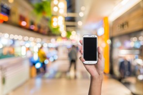 Using smartphone in a market or department store, closeup image.