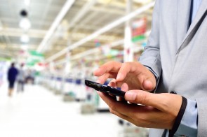 Business Man using mobile phone while shopping in supermarket.