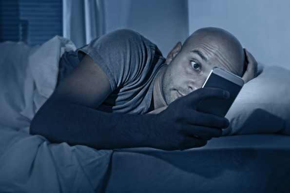 mobiel-kijken-in-bed-fotolia