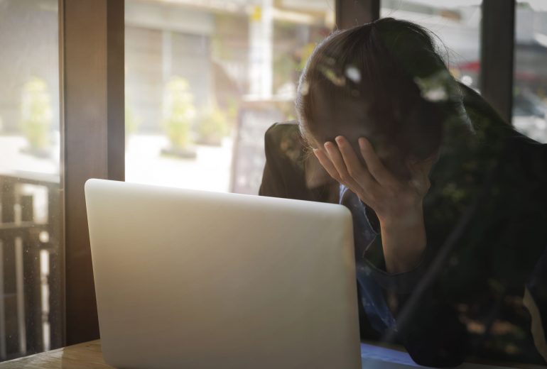 facepalm achter laptop