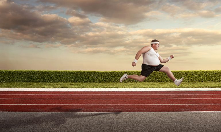 39373622 - funny overweight man speeding on the running track with copy space