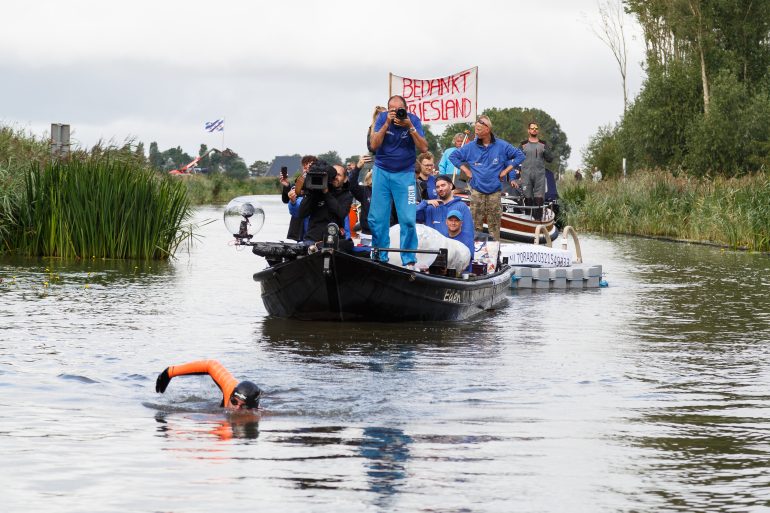 Maarten van der Weijden zwemt zijn 11stedenzwemtocht in 2018, met op de achtergrond volgboten met de onboard reporter.