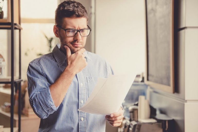 man leest formulier met twijfelachtige blik. Is de taal verwarrend?