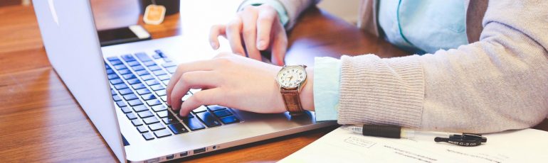 Copywriting handen tikken op laptop