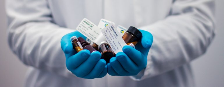 Afbeelding van een dokter die medicijnen vasthoudt.