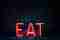 Eat logo voor een donkere muur.