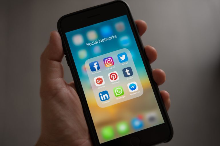 Foto van smartphone met social-media-icoontjes erop