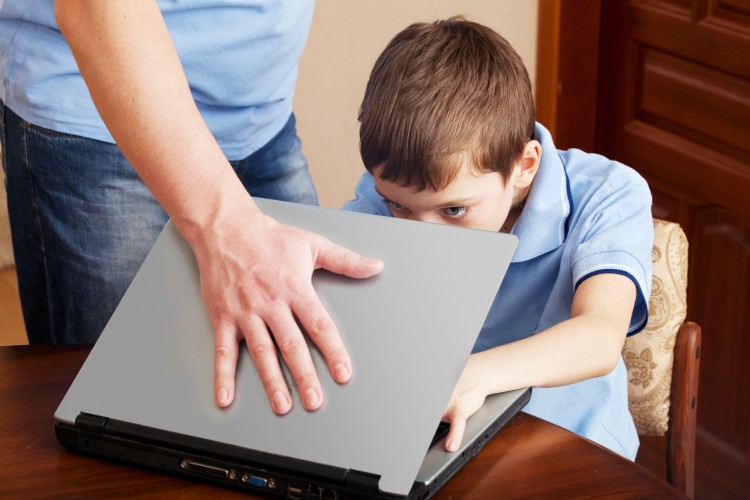 Afbeelding van een ouder die de laptop van een kind dichtklapt.
