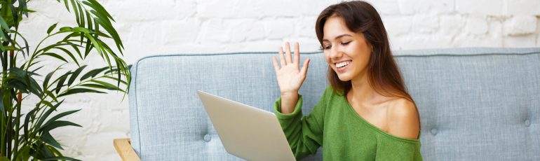 Vrouw vergadert met webcam op de bank.