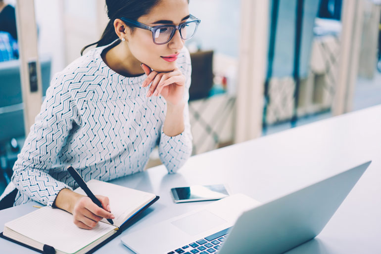 Vrouw maakt aantekeningen van webinar.