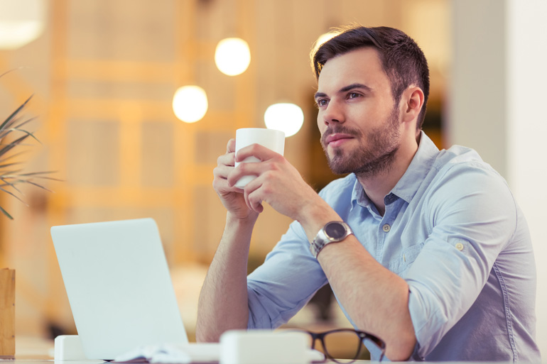 Man denkt na over blogs met kopje koffie.