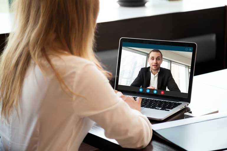 Vrouw kijkt naar videotraining op laptop.