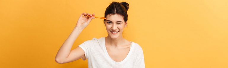 Vrouw knipoogt, met pen in hand.
