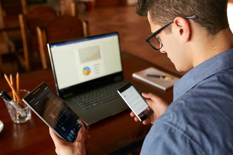 Man met telefoons en laptop.