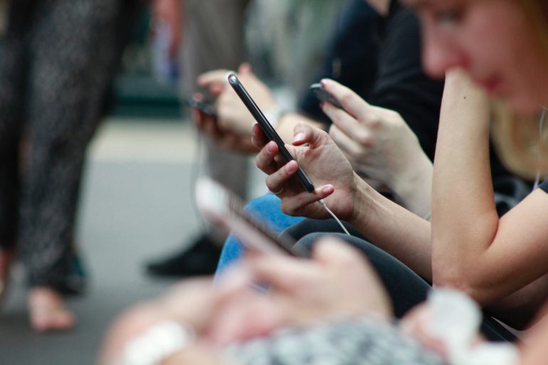 Mensen op hun telefoon, dat 'digitalisering' weergeeft.