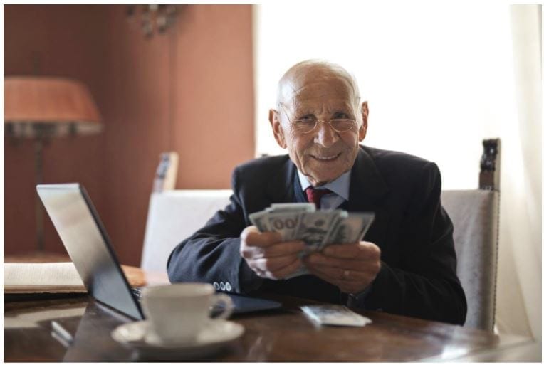 Oude man met geld in zijn handen. Bron: Pexels.