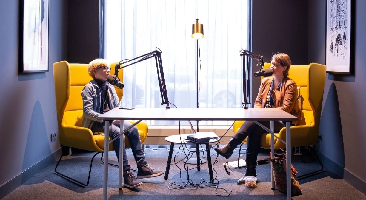 Twee personen die aan het podcasten zijn.