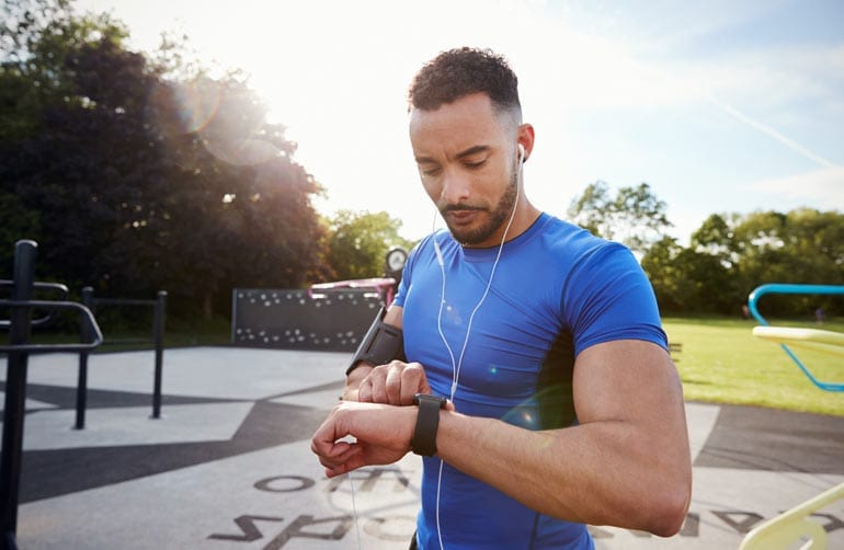 Man draagt sporthorloge tijdens hardlopen.