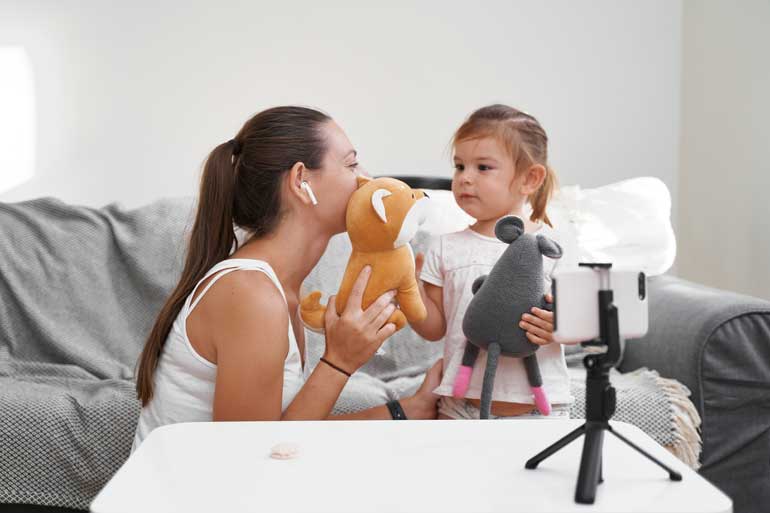 Mommy blogger en kind voor camera.