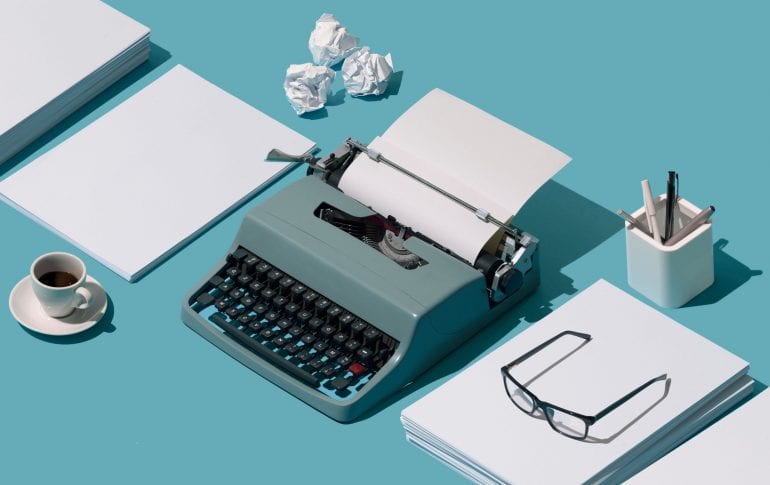 Lege en verkreukelde vellen papier en een typemachine