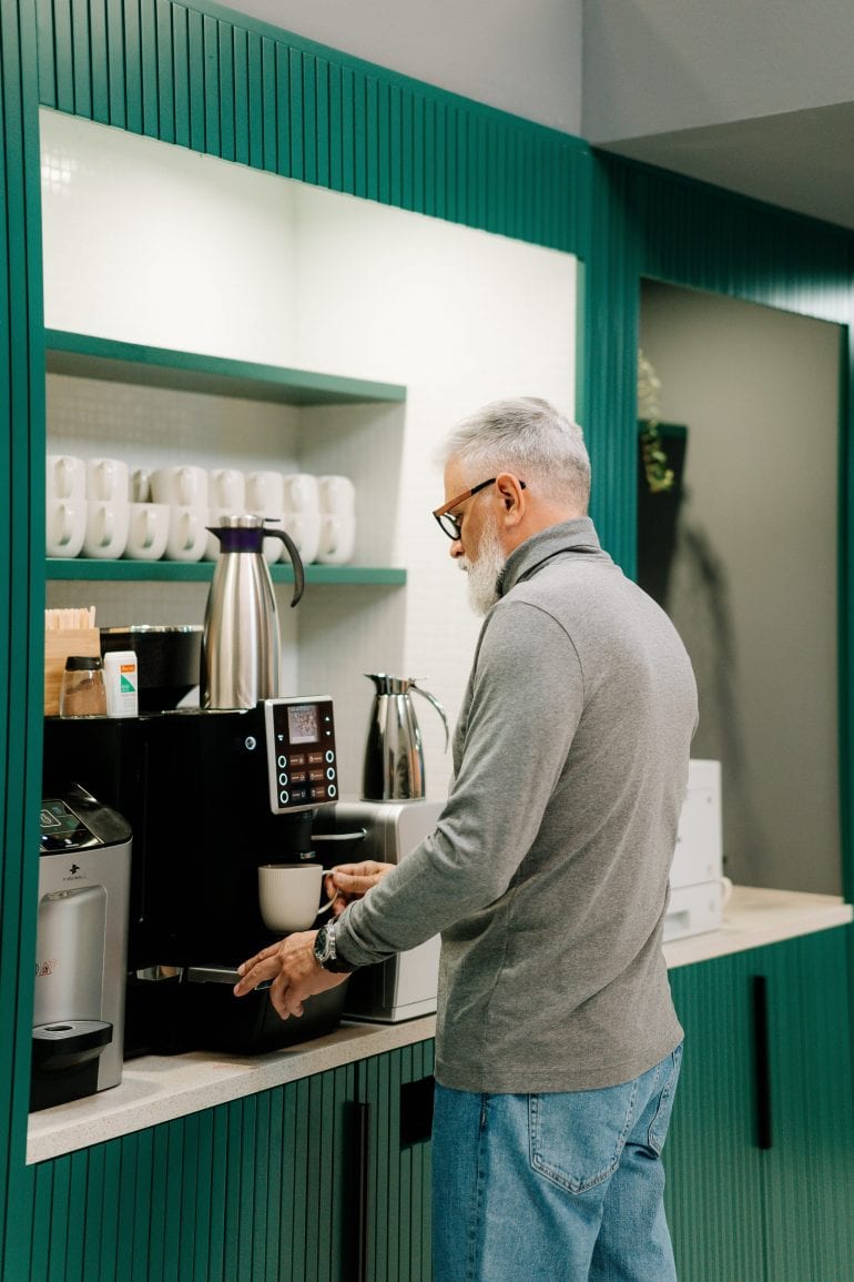 Foto van een man bij een koffieautomaat