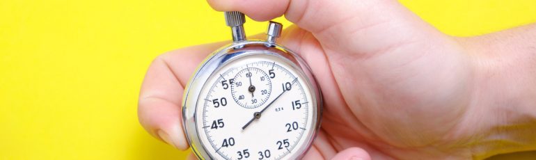 Stopwatch in hand op gele achtergrond bij SEO-quickscan in 30 minuten