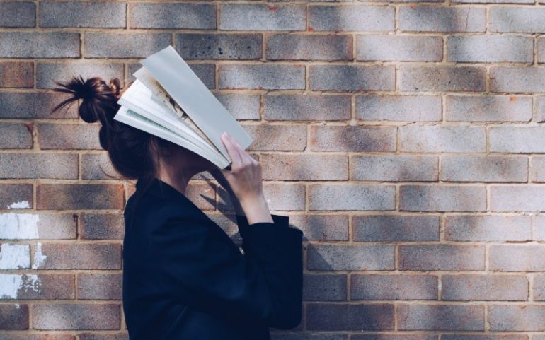 Vrouw met boek op haar hoofd