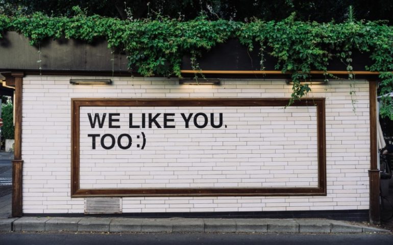 Muur met tekst we like you too bij social media update