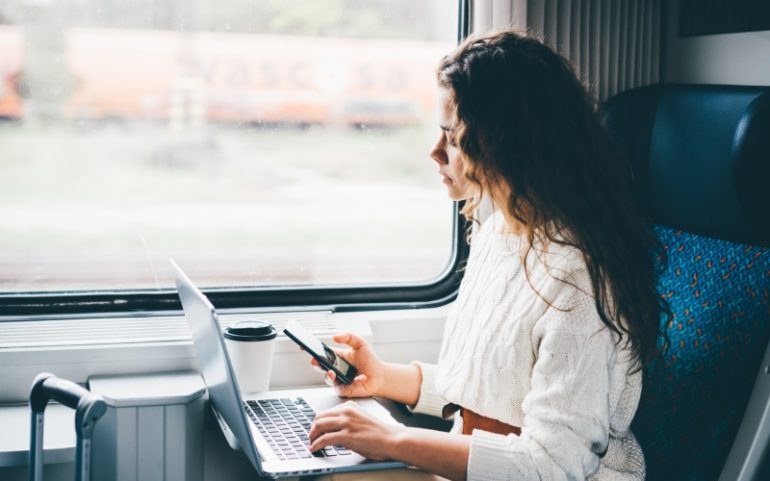 Vrouw werkt hybride in de trein