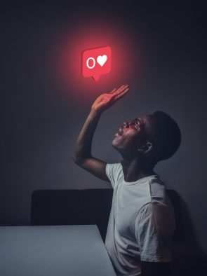 Foto van een man die reikt naar een like-knop met nul likes.