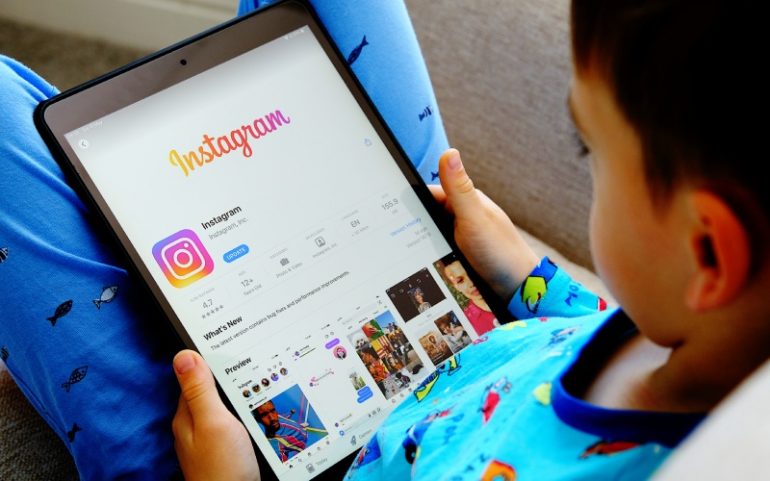 Jongetje met tablet en Instagram-app ter illustratie van Instagram Kids