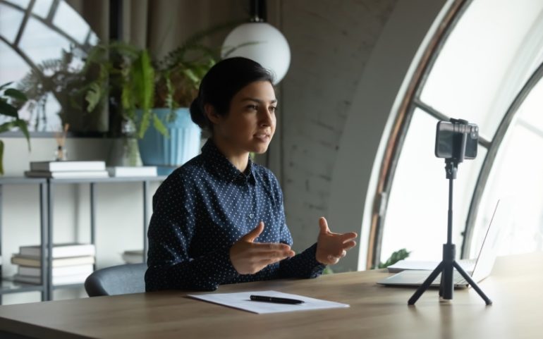 Vrouw filmt video met smartphone ter illustratie van cursus op Instagram