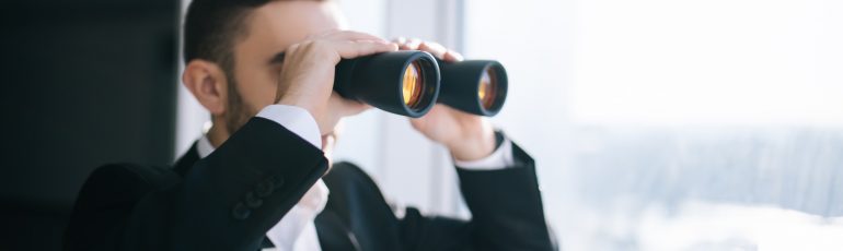Zakenman met verrekijker ter illustratie van kijken naar ontwikkelingen in marketing automation in 2022