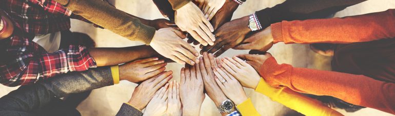 Alle handen op elkaar dat staat voor teamwork.