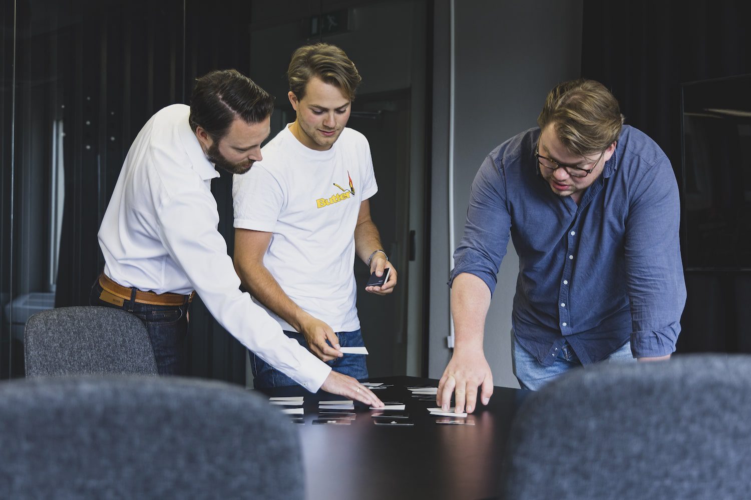 Mannen verschuiven kaartjes met tekst over customer journey