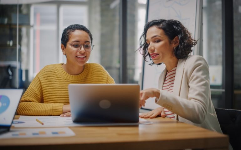 Twee mensen bespreken marketing-software achter laptop