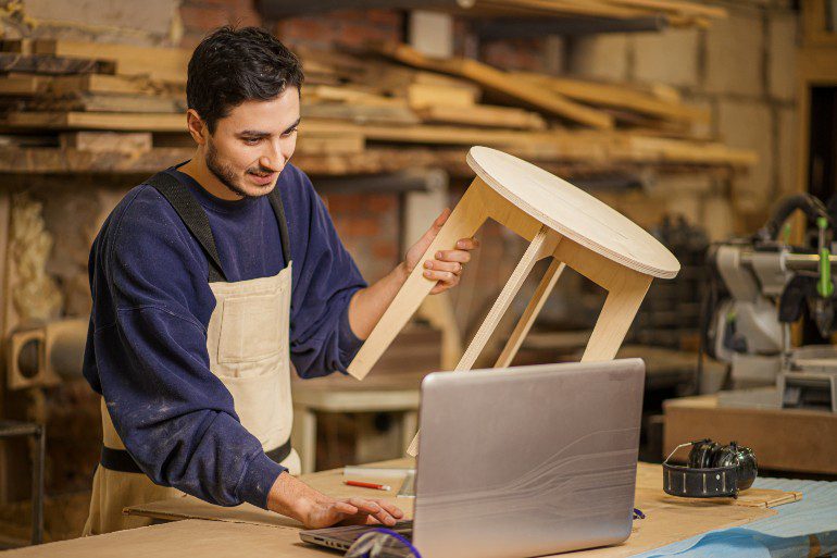 Meubelmaker werkt aan contentmarketing op laptop.