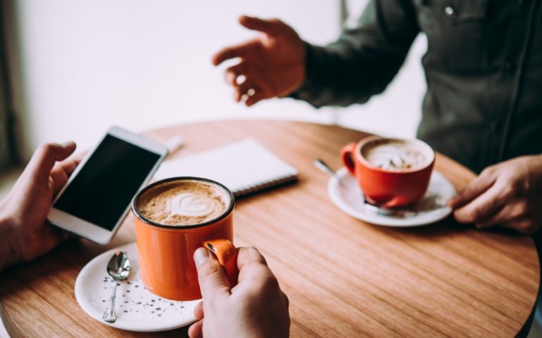 Mensen drinken koffie bij interview om klantcase te schrijven