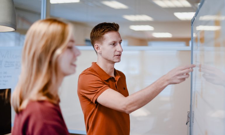 Projectmanagers bespreken zaken voor bord