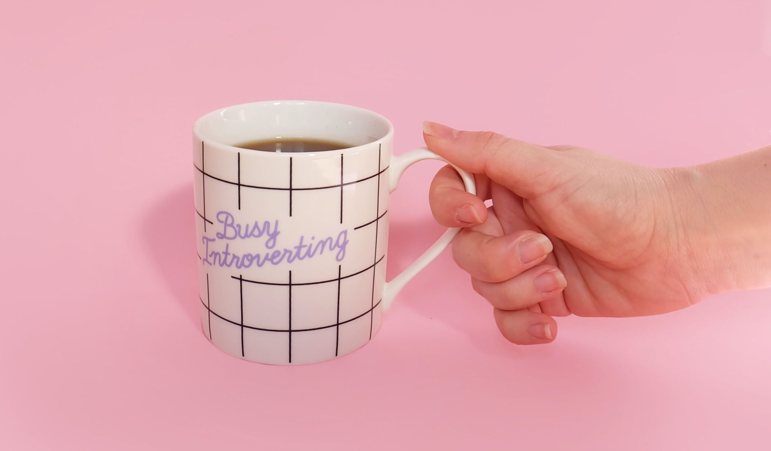 Een mok met daarop de tekst: busy introverting.