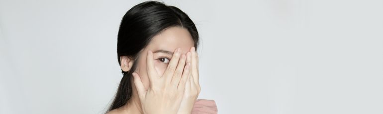 Vrouw verstopt haar gezicht achter haar handen