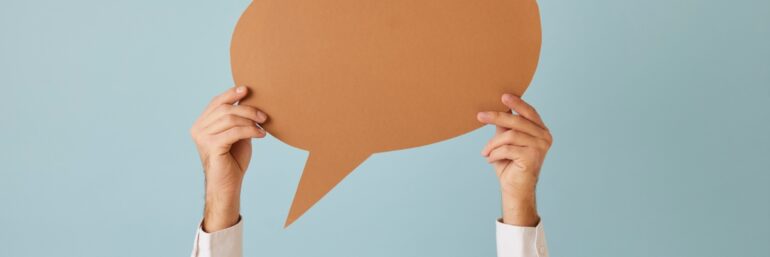 Handen die spraakballon vasthouden ter illustratie van iemand aanspreken
