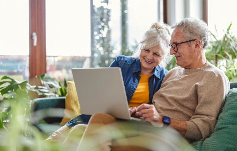 Ouder echtpaar bekijkt samen laptop