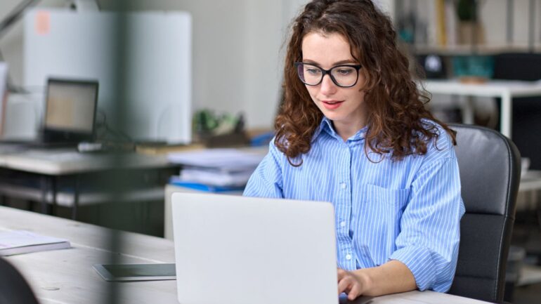 vrouw achter laptop kijkt naar digitaal toegankelijke website