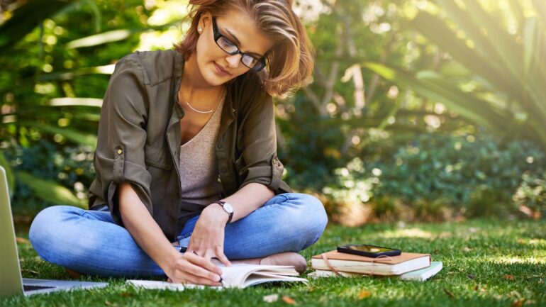 vrouw die in notitieboekje aan het schrijven is