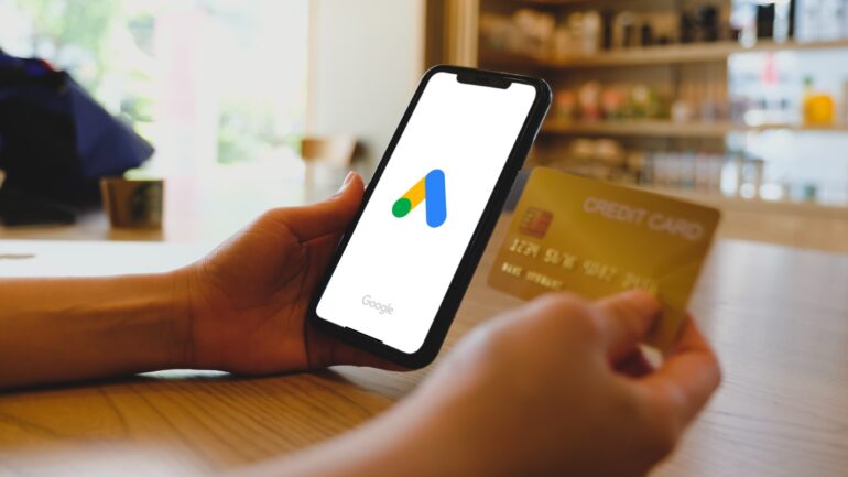 Google Ads op telefoon met creditcard ernaast - Bron: Thaspol Sangsee / Shutterstock.com