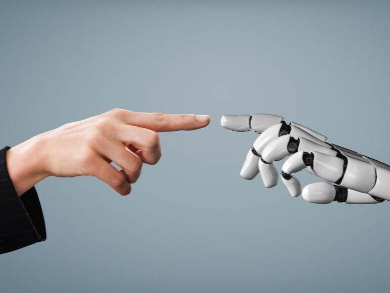 Een mensenhand en robothand raken elkaar. 